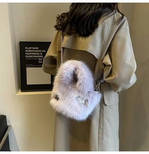Detailed view of plush purple faux fur bag with black bow and star patch detail