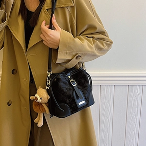 Sac seau chic en velours noir avec matelassage en losanges et accessoire de charme d'ours