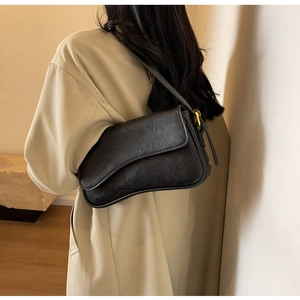 Detail view of large black vintage underarm bag with smooth curved leather texture