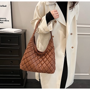 Close-up of a brown quilted puffer tote bag with diamond stitching for commuting