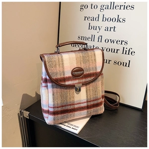Detail view of British vintage plaid backpack with leather handle and metal lock