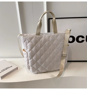 Close-up of white quilted puffer nylon tote bag with adjustable shoulder strap