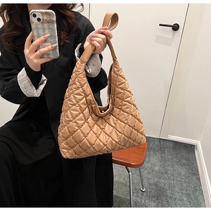 Detailed close-up of khaki quilted tote bag featuring padded diamond lattice stitching