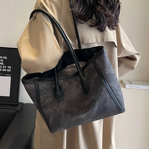 Large dark grey suede tote bag with black leather trim shown on model for daily commuting