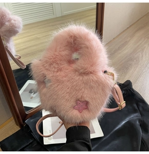 Detailed shot of pink plush faux fur bucket bag with sequin star and gold metal hardware