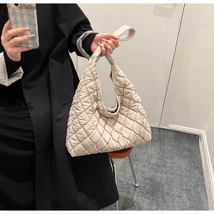 Close-up of beige quilted tote bag showing plush texture and rhombus stitching details