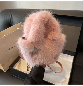 Macro detail of soft pink fluffy faux fur bucket bag with a star charm and thin strap