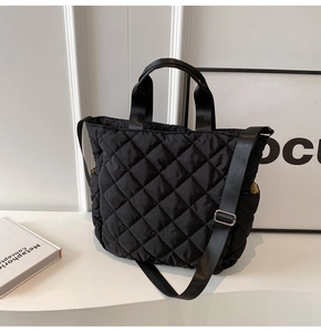 Dettaglio della borsa a tracolla nera trapuntata con texture in nylon e fodera gialla