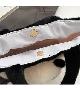 Gros plan sur la boucle magnétique dorée du sac cabas en peluche douce panda