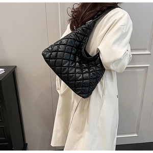 Detail view of a black quilted tote bag showing its soft texture and large capacity