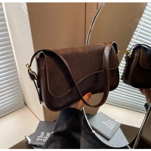 Detail of vintage dark brown faux leather shoulder bag with golden metallic clasp