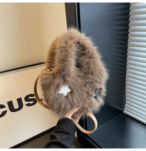 Close-up of fluffy brown bucket bag with star patches and smooth leather shoulder strap