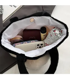 Vue intérieure d'un cabas en peluche noire avec fermoir magnétique et grand espace