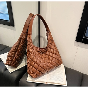 Detailed view of brown quilted hobo bag with padded diamond pattern and half-moon shape