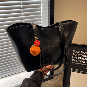Large black shiny tote bag in PU leather with decorative orange persimmon charm