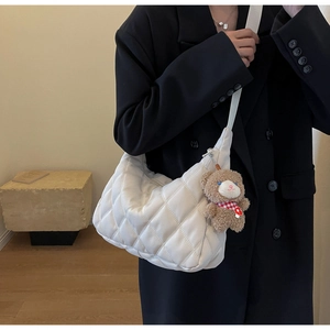 Quilted beige half-moon tote bag with cute plush bear charm detail on strap