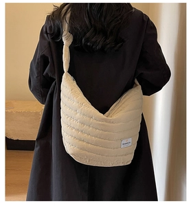 Détail du sac bandoulière matelassé beige avec bandoulière nouée et étiquette tissée