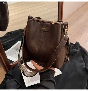 Détail du sac seau marron foncé avec bandoulière large en jacquard géométrique coloré