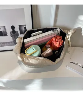 Détail macro de l'intérieur spacieux d'un sac bandoulière beige matelassé avec des objets