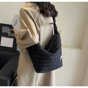 Sac à bandoulière matelassé noir montrant la grande capacité et la texture sur un mannequin