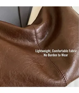 Detailed macro view of coffee brown lychee textured leather with precise double stitching