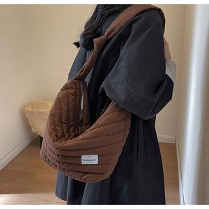 Détail du sac à bandoulière en nylon matelassé marron avec large sangle et zip métallique
