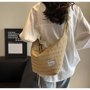 Détail du sac dumpling en nylon matelassé beige avec bandoulière nouée et étiquette