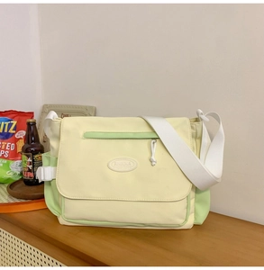 Detalle de bolso tote de lona bicolor con correa ancha y bolsillo frontal con cremallera