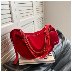 Détail du sac demi-lune rouge en toile avec chaîne argentée et mini porte-monnaie rond