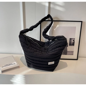 Détail du sac dumpling en nylon matelassé noir montrant la texture épaisse et le zip argent