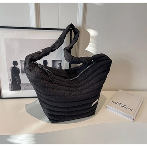 Détail du sac hobo en nylon matelassé noir avec coutures parallèles et fermeture éclair