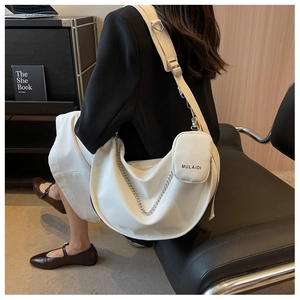 Détail du sac bandoulière demi-lune blanc avec chaîne argentée et pochette amovible