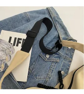 Detail of adjustable black nylon strap and zipper on beige canvas crossbody bag