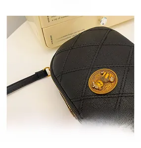Détail de la texture en cuir noir matelassé avec des ornements en métal doré élégants