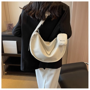 Vue de dos détaillée d'un sac à bandoulière blanc avec chaîne argentée et mini pochette