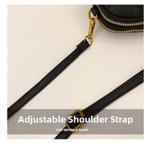 Détail du sac bandoulière en cuir noir avec sangle réglable et boucles dorées