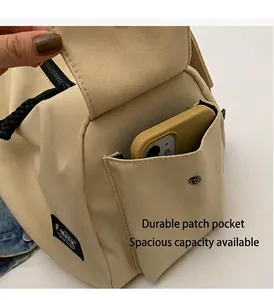 Detail view of khaki nylon utility bag featuring a side pocket for smartphone storage