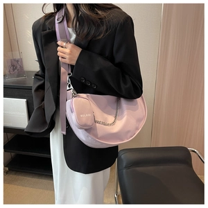 Détail du sac croissant violet avec bandoulière tissée et chaîne décorative argent