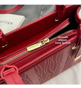Gros plan du détail de la fermeture éclair dorée sur un sac à main de mariage rouge