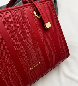 Detailaufnahme der roten Hochzeits-Handtasche mit 3D-Wellenstruktur und goldenen Akzenten