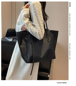 Détail d'un grand sac cabas noir avec pampilles élégantes pour une tenue de bureau chic