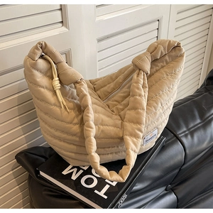 Détail du sac croissant en nylon matelassé avec étiquette de marque et bandoulière