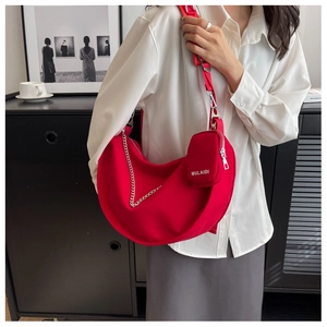 Détail du sac hobo croissant rouge avec chaîne argentée et petit porte-monnaie