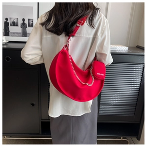 Détail du sac croissant rouge avec chaîne argentée et breloque MULAIDI sur mannequin