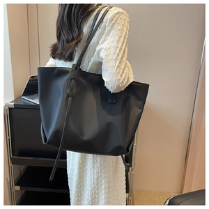 Grand sac cabas noir minimaliste avec détail de tirette longue pour le trajet quotidien