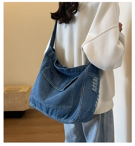 Macro di borsa tote in denim blu con cuciture bianche a vista e trama invecchiata