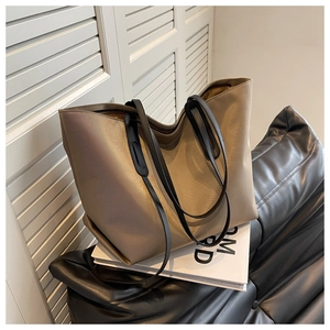 Détail du grand sac cabas en nylon kaki avec anses en cuir noir sur fond minimaliste