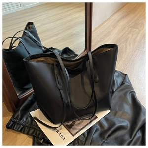 Détail d'un grand sac cabas noir minimaliste avec de longues anses en cuir
