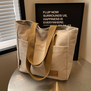 Large capacity canvas tote bag with multi-pocket design and beige woven handles