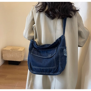 Dettaglio borsa a tracolla in denim con bordi sfrangiati e tasca con patta grande